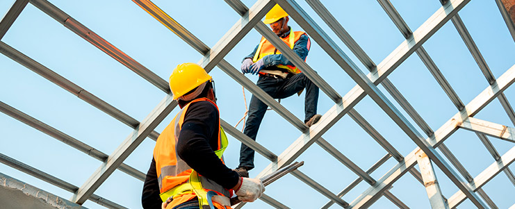 A team of construction workers on a roof, highlighting Texas's commercial construction to support expanding businesses.