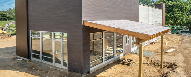 An under-construction building with an awning and multiple windows, highlighting the development process. commercial construction