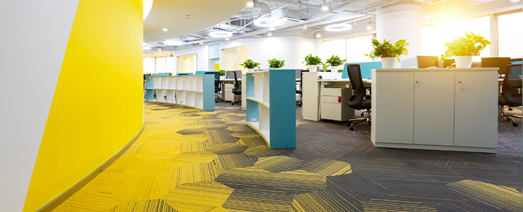An office space with a cheerful yellow wall complemented by blue decor, designed for a lively work environment.