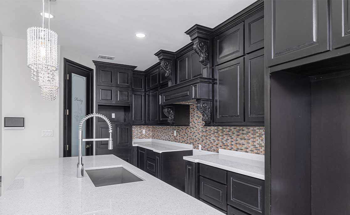 Stylish kitchen with black cabinetry and polished marble countertops, showcasing contemporary design for new homeowners.